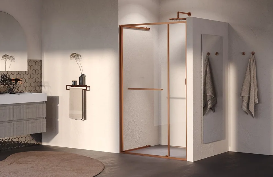 Warme badkamer met een licht meubel en glazen doucheopstelling met koperkleurige profielen.